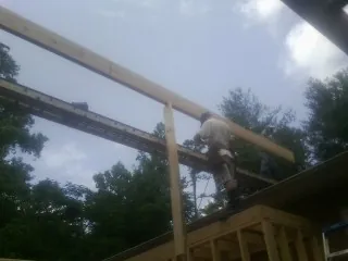 Carpenter setting a ridge beam over a new addition frame — Ice Dam Removal by Roofing Brothers in Bloxom