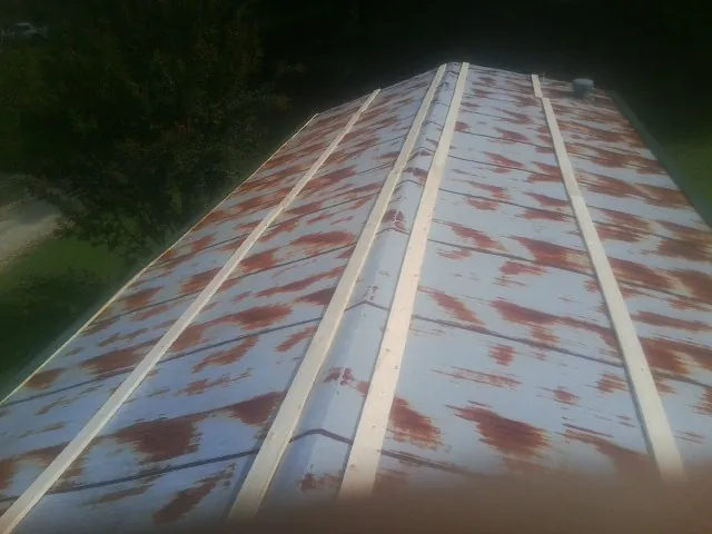 Rusted metal roof panels with new wood purlins before replacement — Storm Damage Roof Repair in Bloxom by Roofing Brothers